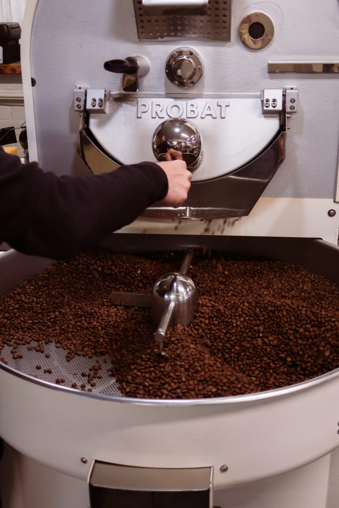 Coffee beans cooling beneath a roasting machine