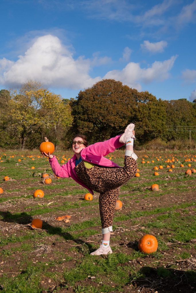 A colourful personal-brand portrait in a pumpkin field