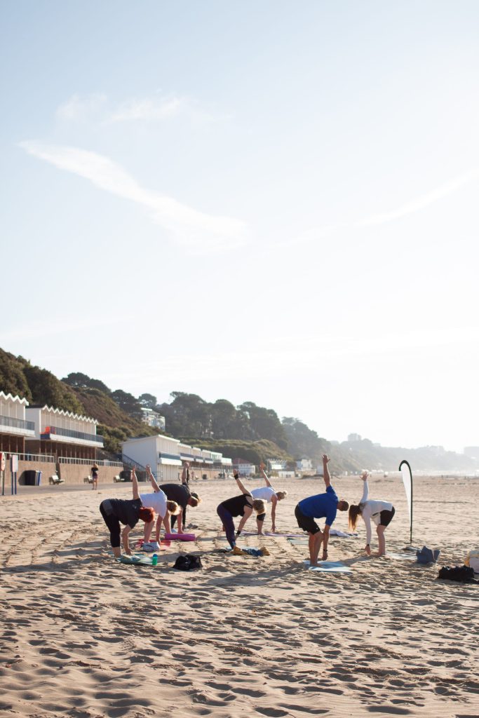 A Pilates class exercising on the beach