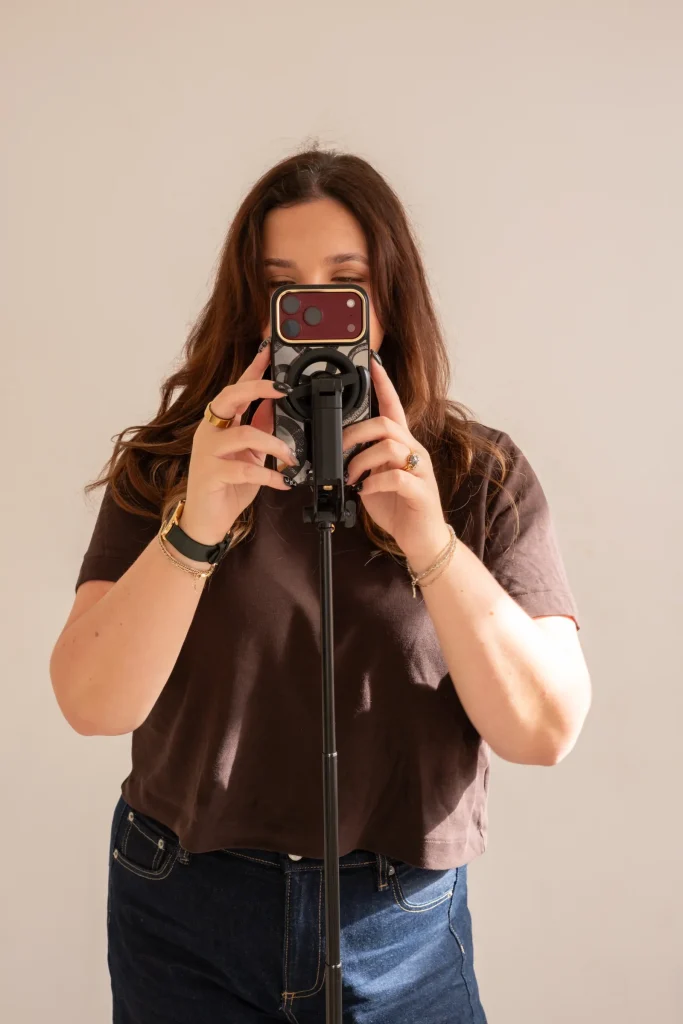 Jaye filming with a phone mounted on a tripod