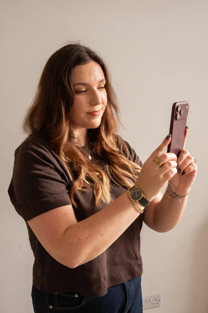 Jaye looking at her phone in warm sunlight