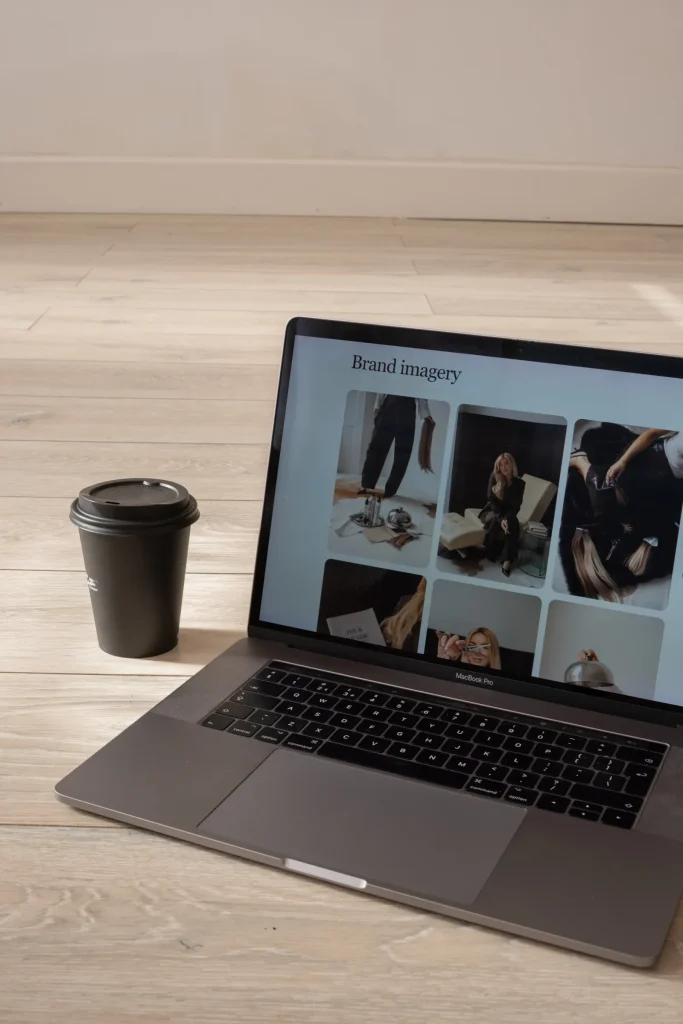 A laptop displaying Jaye’s brand imagery portfolio beside a coffee