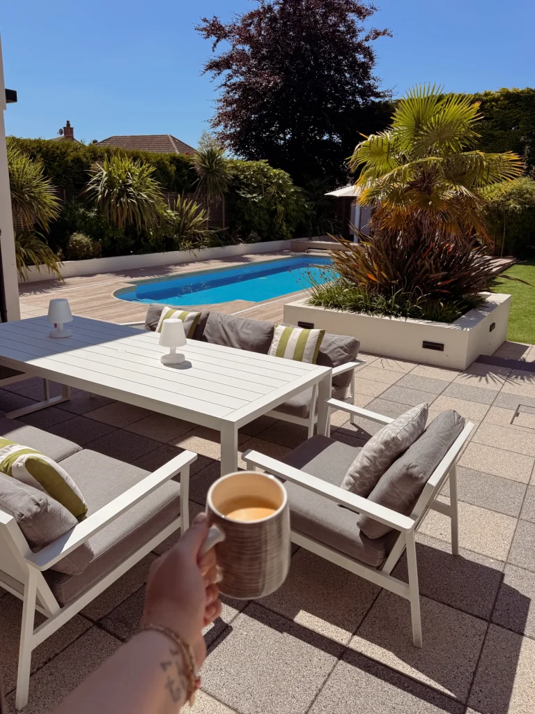 Outdoor dining area beside a swimming pool
