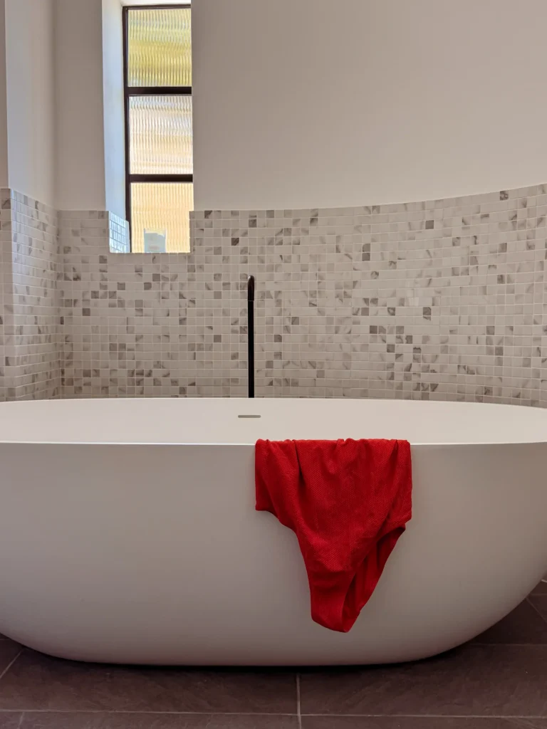 Freestanding bathtub with a red towel