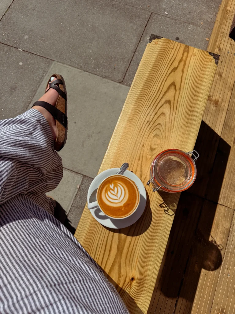 Cup of coffee with latte art on an outdoor bench