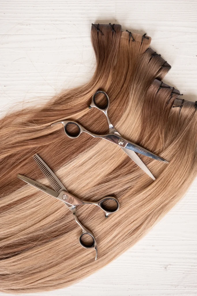 Hair extension swatches arranged with scissors on a white background