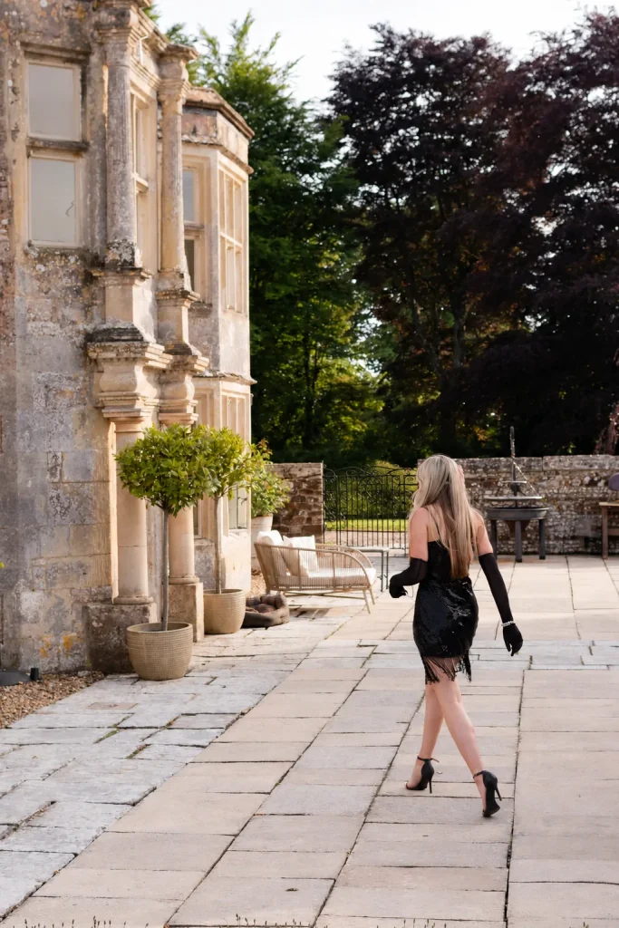Guest in a black dress walking through the stone courtyard