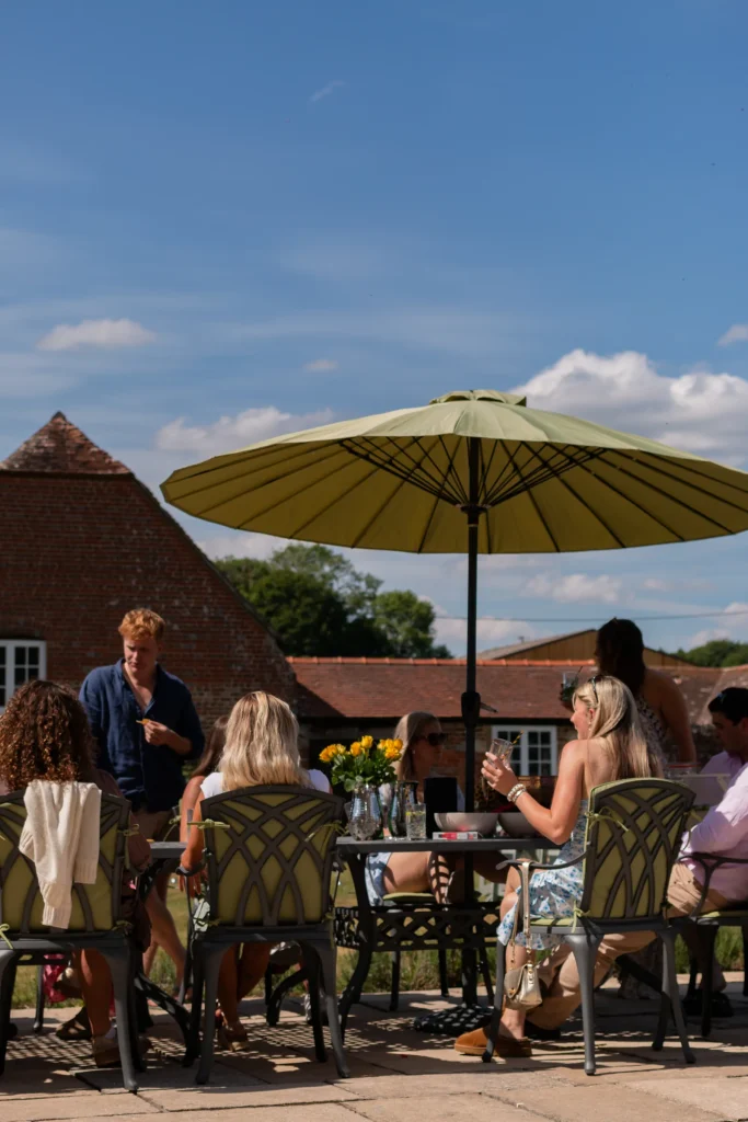 Guests gathered around a table beneath a garden parasol