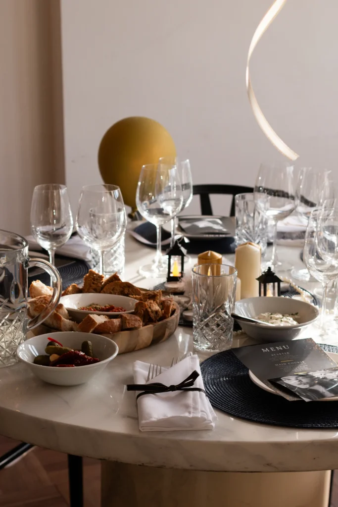 Dining table set with glasses, candles and food