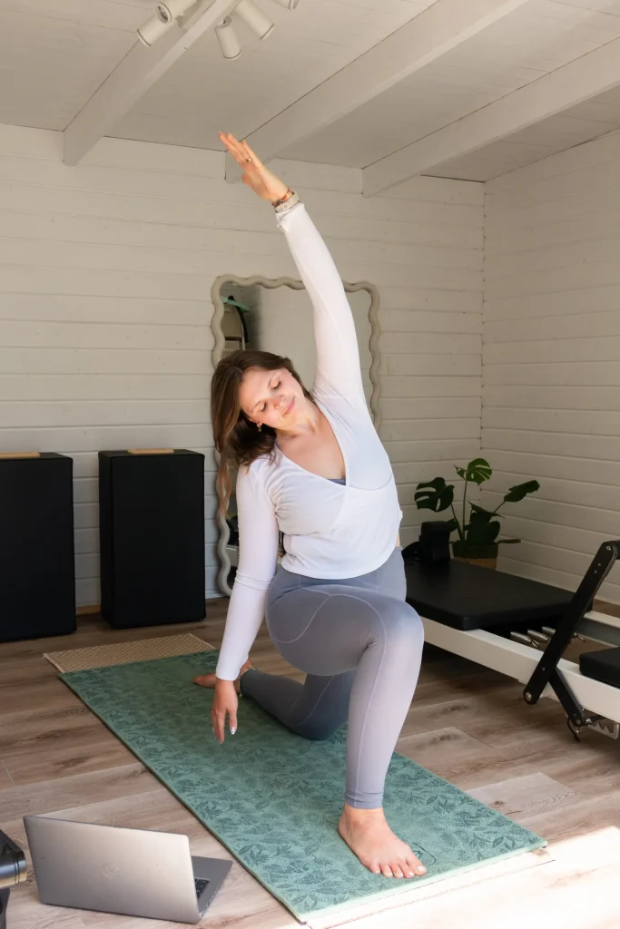 Pilates instructor stretching in a kneeling lunge
