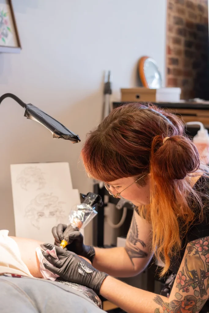 Tattoo artist working on a client’s arm