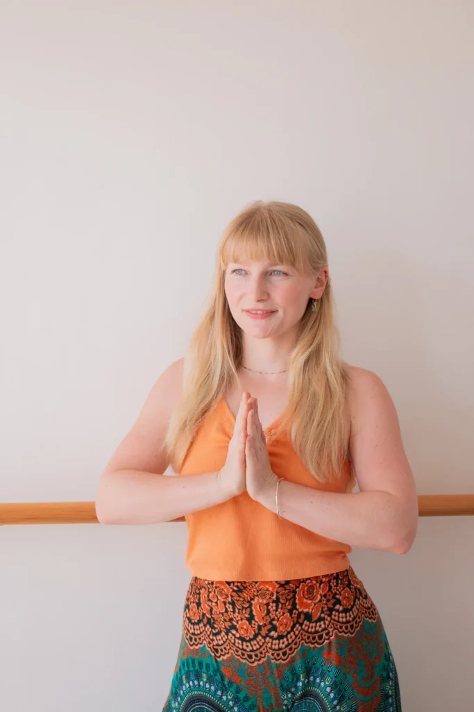 Woman standing with palms together in a yoga studio